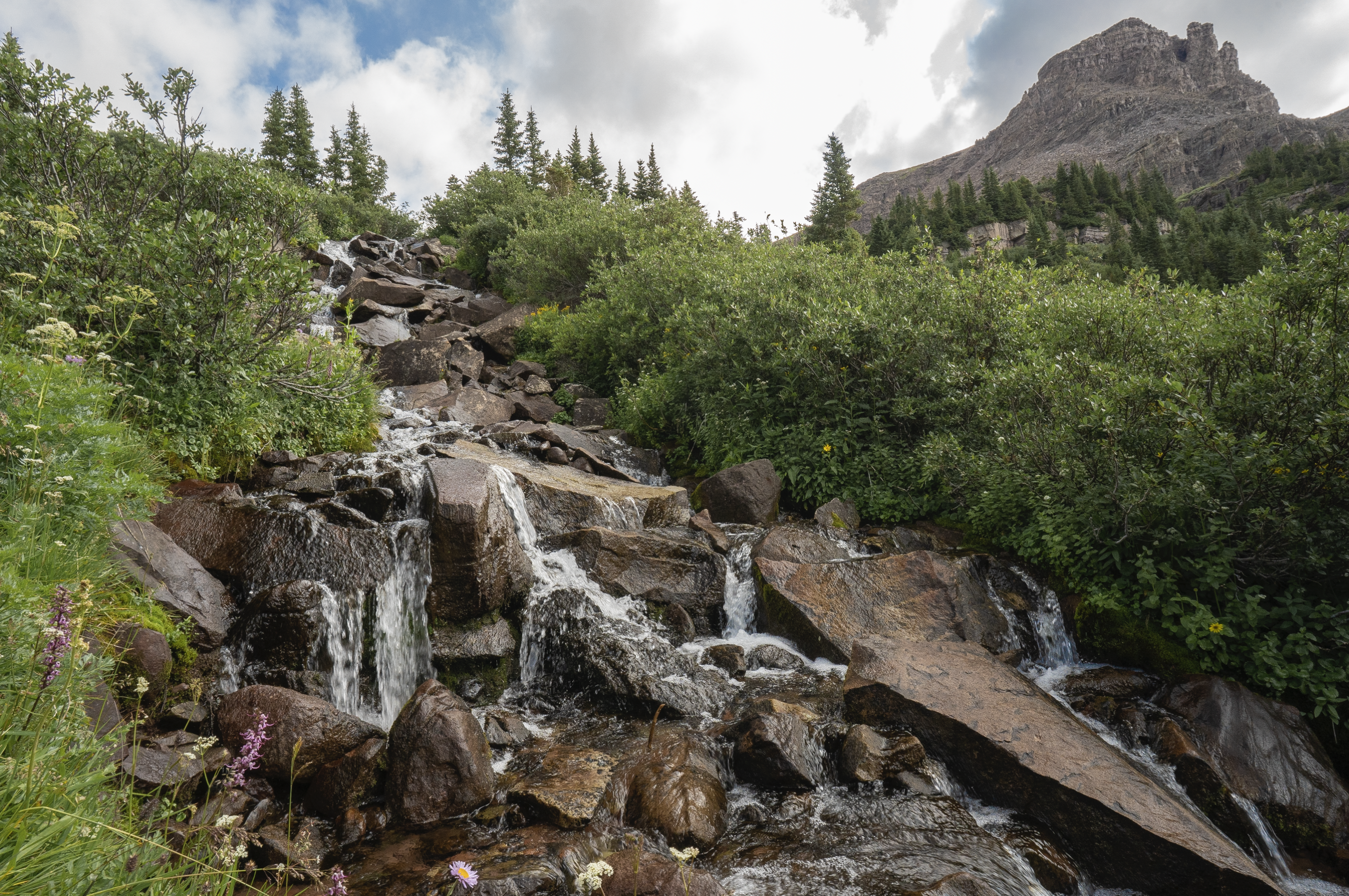 Scene of a mountain cascade rushing towards the camera diagonally top left to bottom right of frame