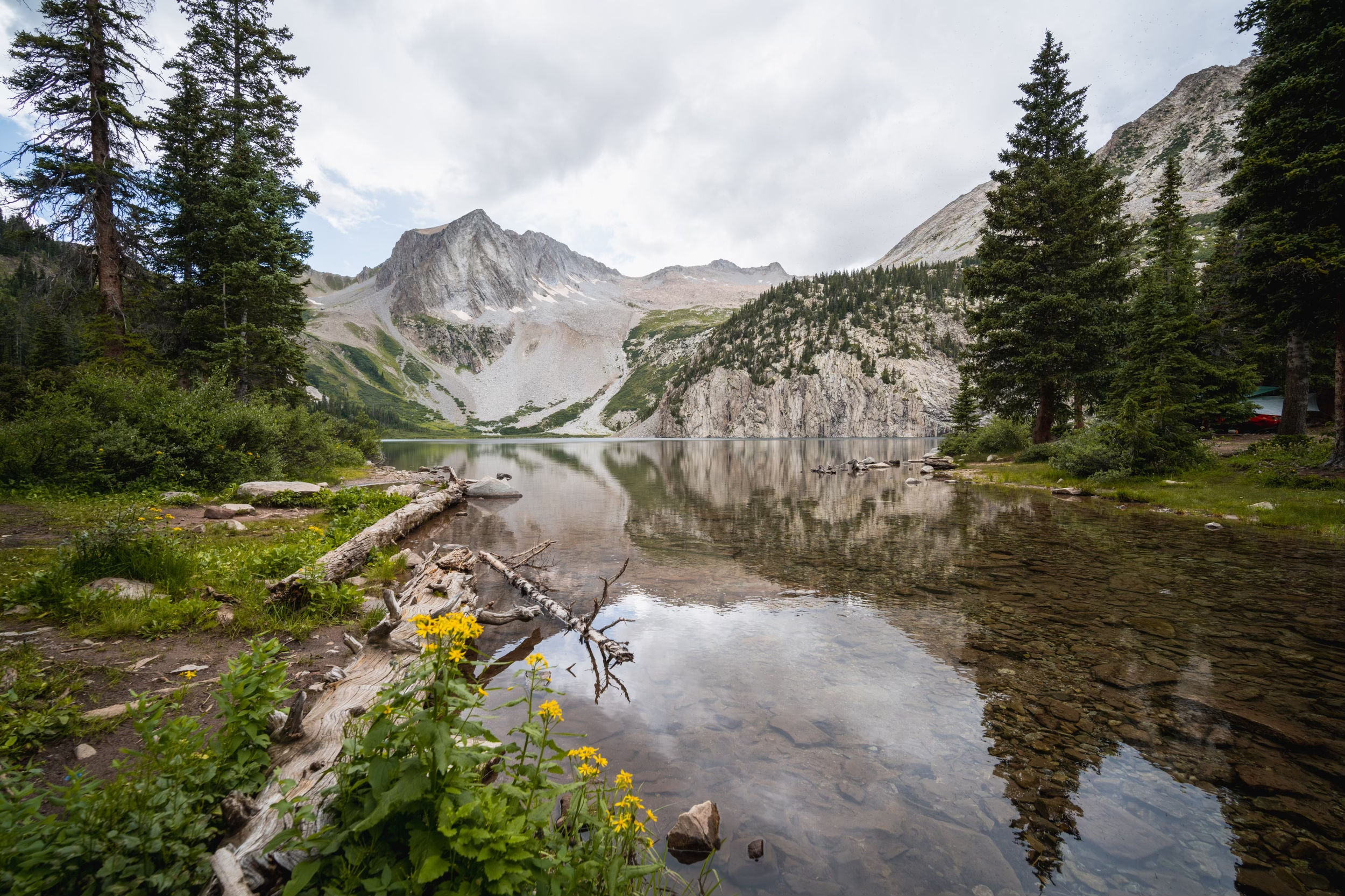 Arriving to a cloudy Snowmass Lake, mountains in the background